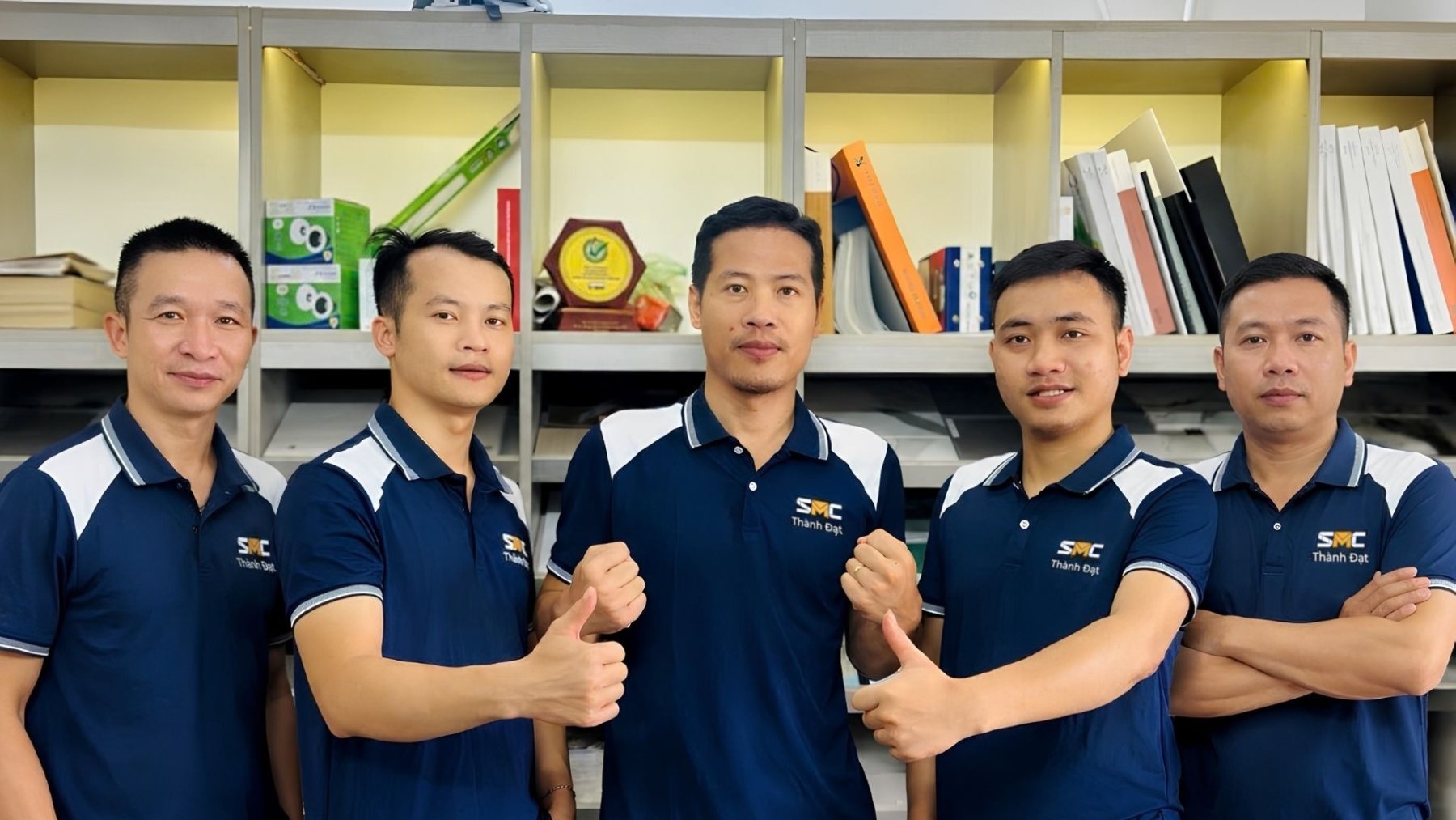 Đội ngũ SMC Thành Đạt mặc áo polo thương hiệu, chụp tại văn phòng